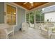 Screened porch with white wicker seating, tile floors and a ceiling fan for relaxing outdoors at 622 Sunset Ave, Apex, NC 27502
