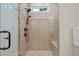 Close-up view of the tiled shower with a glass door, mosaic tile detail, and shower head with body sprays at 622 Sunset Ave, Apex, NC 27502