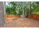 Private backyard with a fire pit area, mature trees, and a fenced perimeter, creating a cozy retreat at 6304 Ansley Ln, Raleigh, NC 27612