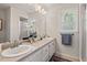 Bathroom with a double sink vanity, neutral countertop, framed mirror, and natural light from a window at 6304 Ansley Ln, Raleigh, NC 27612