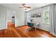 Bright bedroom with hardwood floors, fan, a desk with a chair, and natural light from two windows at 6304 Ansley Ln, Raleigh, NC 27612