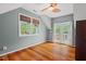 Light-filled bedroom with wood floors, windows, a ceiling fan, and access to a balcony at 6304 Ansley Ln, Raleigh, NC 27612