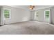 Spacious bedroom with plush carpet, ample natural light from three large windows, and a ceiling fan at 6304 Ansley Ln, Raleigh, NC 27612