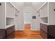 Walk-in closet featuring custom shelving, drawers, and hardwood floors at 6304 Ansley Ln, Raleigh, NC 27612