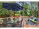 Outdoor deck featuring a patio table with umbrella and surrounding trees at 6304 Ansley Ln, Raleigh, NC 27612