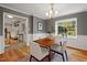 Bright dining room with hardwood floors, stylish chandelier, and large window at 6304 Ansley Ln, Raleigh, NC 27612