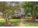 Two-story house with a brick-lined porch, lush green lawn, and mature shade trees at 6304 Ansley Ln, Raleigh, NC 27612