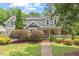 Charming two-story home featuring a brick porch, gray siding and mature landscaping at 6304 Ansley Ln, Raleigh, NC 27612