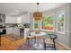 Updated kitchen with white cabinets, wood floors, and pendant lighting over breakfast nook at 6304 Ansley Ln, Raleigh, NC 27612