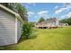Expansive backyard showcasing a large deck, detached garage, and a lush green lawn, ideal for relaxation and recreation at 701 Creekside Dr, Clayton, NC 27520