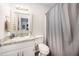 Bright bathroom with a white vanity, granite countertop, and a shower-tub combo with a gray curtain at 701 Creekside Dr, Clayton, NC 27520