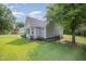 Side view of home with well-maintained lawn, mature tree, and manicured landscaping at 701 Creekside Dr, Clayton, NC 27520