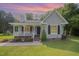 Charming single Gathering home with a well-maintained lawn and inviting front porch at sunset at 701 Creekside Dr, Clayton, NC 27520