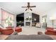 Bright living room featuring a stone fireplace, ceiling fan, and neutral carpeting at 701 Creekside Dr, Clayton, NC 27520