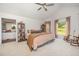 Cozy main bedroom featuring a ceiling fan, ensuite bathroom, plush carpet and a rocking chair at 701 Creekside Dr, Clayton, NC 27520