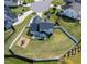 Aerial view of a home with a large, fenced backyard, play set, and outdoor seating area at 77 Redpine Ct, Clayton, NC 27520