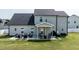 Spacious backyard showcasing a patio, lush lawn, and the home's exterior with a dark roof and light siding at 77 Redpine Ct, Clayton, NC 27520