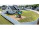 Aerial view of a spacious backyard with a play structure, patio, and lush lawn enclosed by a white fence at 77 Redpine Ct, Clayton, NC 27520