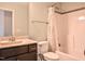 Bright bathroom featuring a shower with a bathtub, a decorative shower curtain, and a dark wood vanity with a light countertop at 77 Redpine Ct, Clayton, NC 27520