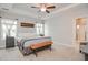 Bright primary bedroom featuring tray ceilings, ceiling fan and ensuite bath at 77 Redpine Ct, Clayton, NC 27520