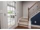 Welcoming entryway with staircase, hardwood floors, and glass door leading to an outdoor patio at 77 Redpine Ct, Clayton, NC 27520