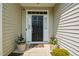 Inviting front entryway with a black door flanked by sidelights and planters with colorful flowers at 77 Redpine Ct, Clayton, NC 27520