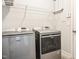 Modern laundry room featuring Maytag washer and dryer, with overhead storage shelves and tile flooring at 77 Redpine Ct, Clayton, NC 27520