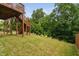 Spacious backyard featuring a wooden deck with stairs, lush green grass and mature trees at 817 Stable Fern Dr, Fuquay Varina, NC 27526