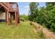 Backyard showing a wooden deck, privacy fence, green grass and tall vegetation at 817 Stable Fern Dr, Fuquay Varina, NC 27526