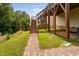 Backyard showing a wooden deck with stairs, a brick walkway and green grass lawn at 817 Stable Fern Dr, Fuquay Varina, NC 27526