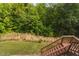 Wooden deck steps lead to the backyard and grassy lawn surrounded by lush trees at 817 Stable Fern Dr, Fuquay Varina, NC 27526