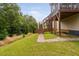 Backyard features a brick walkway leading to a wooden deck with stairs, and lush green grass at 817 Stable Fern Dr, Fuquay Varina, NC 27526