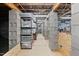 Long basement hallway with concrete walls and shelves lined with plastic storage containers at 817 Stable Fern Dr, Fuquay Varina, NC 27526