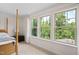 Bright bedroom featuring three large windows with lush green views at 817 Stable Fern Dr, Fuquay Varina, NC 27526