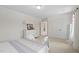 Bright bedroom with plush carpeting, light walls, large windows, closet, and sitting bench at the end of the bed at 817 Stable Fern Dr, Fuquay Varina, NC 27526