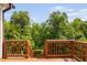 Wooden deck staircase leads to a backyard with a backdrop of lush green trees at 817 Stable Fern Dr, Fuquay Varina, NC 27526
