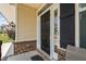 The black front door stands out with its white trim and sidelights, complemented by brick accents and manicured landscaping at 817 Stable Fern Dr, Fuquay Varina, NC 27526