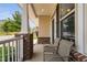 The covered front porch features brick columns, neutral chairs, and a partial view of the neighborhood street at 817 Stable Fern Dr, Fuquay Varina, NC 27526