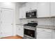 Bright kitchen featuring stainless steel appliances, white cabinets, and granite countertops with subway tile backsplash at 817 Stable Fern Dr, Fuquay Varina, NC 27526