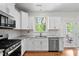 Bright kitchen featuring stainless steel appliances, white cabinets, and granite countertops with subway tile backsplash at 817 Stable Fern Dr, Fuquay Varina, NC 27526