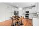 Open-concept kitchen featuring stainless steel appliances, white cabinets, granite counters, and an island with bar stools at 817 Stable Fern Dr, Fuquay Varina, NC 27526