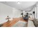 Open-concept living space with hardwood floors and an adjacent kitchen featuring stainless steel appliances and white cabinets at 817 Stable Fern Dr, Fuquay Varina, NC 27526