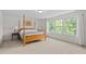 Serene main bedroom with large windows, natural light, and a four-poster bed for a tranquil retreat at 817 Stable Fern Dr, Fuquay Varina, NC 27526