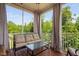 Screened porch with cozy seating and a view of the surrounding trees at 817 Stable Fern Dr, Fuquay Varina, NC 27526