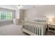 Neutral bedroom with large window, carpet, and furnishings including a white crib at 8201 Ivymount Way, Raleigh, NC 27613