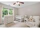 Bright Bedroom with a large window, crib, dresser, and comfortable armchair at 8201 Ivymount Way, Raleigh, NC 27613
