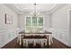 Elegant dining room with chandelier, wainscoting, and large window at 8201 Ivymount Way, Raleigh, NC 27613