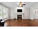 Spacious living room with hardwood floors, fireplace, and modern ceiling fan at 8201 Ivymount Way, Raleigh, NC 27613