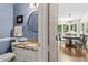 Elegant powder room with granite vanity and round mirror, leading into a dining area at 8508 Zinfandel Pl, Raleigh, NC 27615