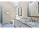Bathroom featuring double sinks with granite countertop, a tile shower, and a skylight at 8508 Zinfandel Pl, Raleigh, NC 27615